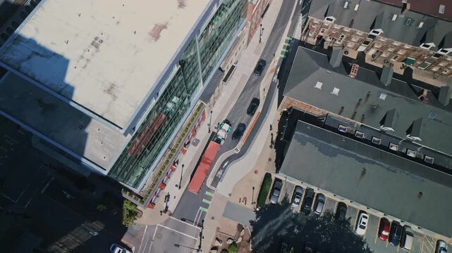 Drone aerial perspective: freight truck drives through vibrant Halifax city center streets with tall buildings. Destination seaport for cargo loading, modern supply chain and delivery concept.