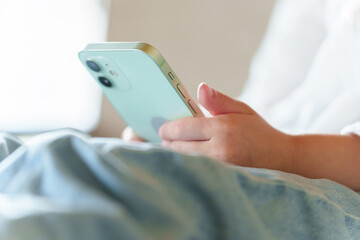 スマートフォンを使う女の子の手元 © taka