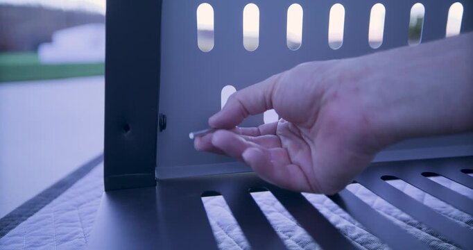 Person's hand using tool to tighten screw into metal structure - closeup shot