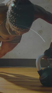 Vertical video: Woman gripping kettlebell shifting into plank toning core with fitness flares
