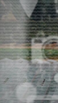 Vertical video: Camera tilting, reflection shifting and fading while roof panels clearing for shot