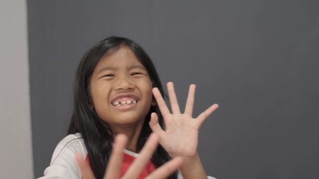 Hysterical little Asian girl crying and looking terrified, panicked child with fearful expression and defensive hand gesture, childhood trauma, bullying, and domestic fear