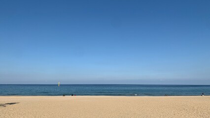 Fototapeta premium Peaceful blue sea and sandy beach under a clear sky in South Korea