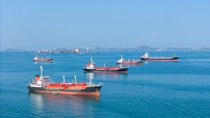 Naklejka premium LPG gas and oil tanker ships anchored in the blue ocean. Industrial maritime transport, global energy logistics, and fossil fuel import export trade concept.