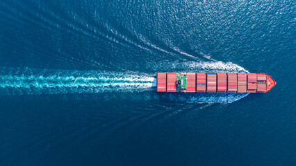 massive container ship loaded with colorful cargo navigating the ocean near a commercial port terminal. Global maritime trade logistics, international freight transport, and supply chain  © Yellow Boat