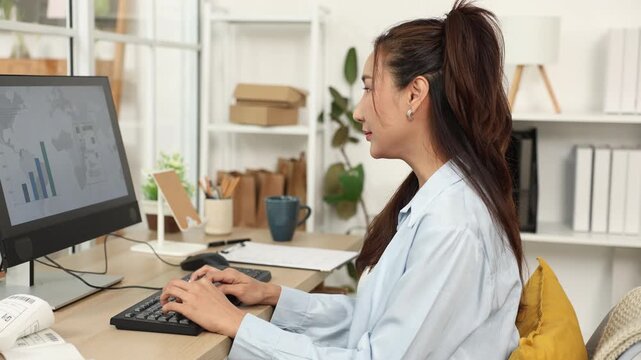 Ecommerce, order, management, online seller works at computer beside packed boxes, managing backend tasks and shipping updates from home warehouse office for efficient small business fulfillment.