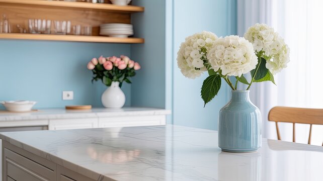 Modern bright kitchen interior with white marble countertop and blue vase of hydrangea flowers