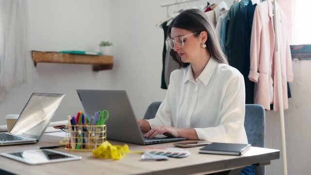 Video of fashion designer  working with laptop in a coworking place