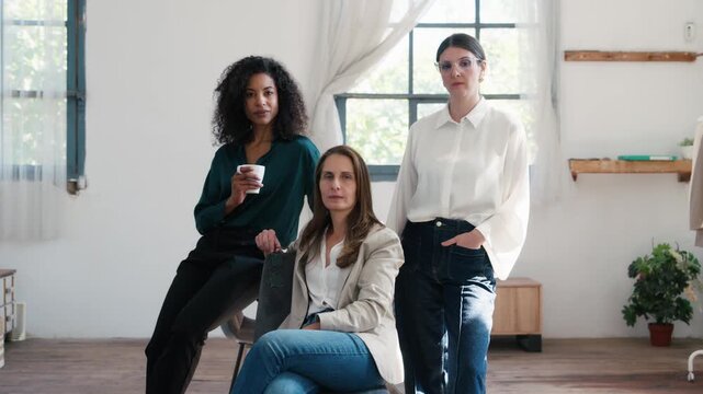 Video of group of fashion designers posing and looking at camera in a coworking place