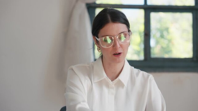 Video of cheerful fashion designer doing a videocall in a coworking place 