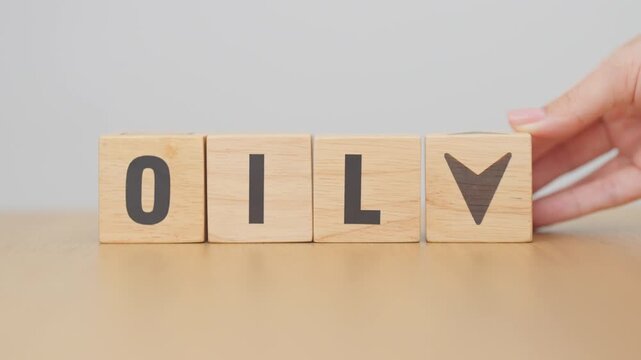 Hand change wooden block with OIL text to UP and Down arrow symbol icon. Trade war, stocks, financial, cut loss and economic concept
