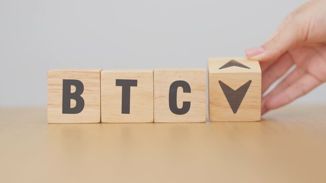 Hand change Wooden block with BTC or Bitcoin text to UP and Down arrow symbol. cryptocurrency, blockchain, price, down and up, decrease and increase, cut loss, trade and financial concepts
