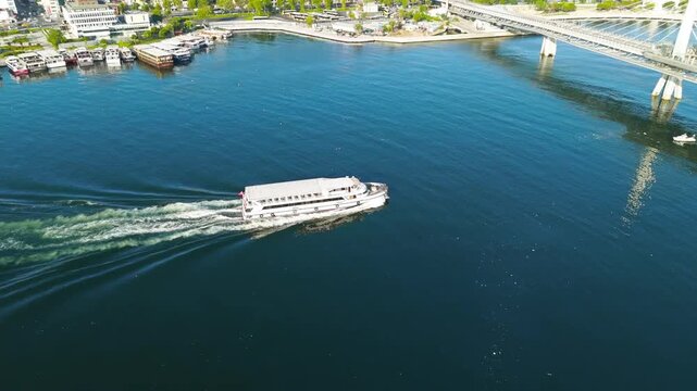 Istanbul, Turkey. Public transport ferry passing under Golden Horn Metro Bridge in Golden Horn Bay at morning sunlight. Aerial View