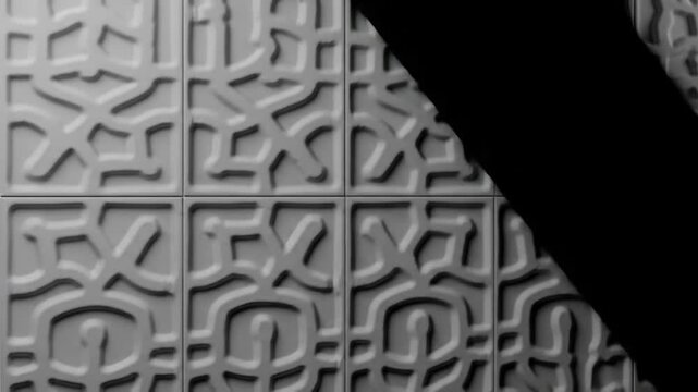 Close-up of a tiled surface in grayscale. The tiles feature a repetitive pattern of interconnected, abstract shapes. A diagonal black shadow covers the image