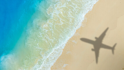 Aerial view of shadow passenger plane silhouette and sandy beach blue sea with waves at sea beach summer vacation sea travel concept	
