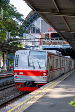 Jakarta, Indonesia - March 17, 2026: A KAI Commuter electric multiple unit (EMU) train stopped at Palmerah Station in Jakarta, Indonesia, with station structures and trees in the background