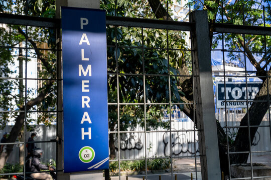 Jakarta, Indonesia - March 17, 2026: The Palmerah Station sign is displayed on a blue vertical board beside the station fence, with trees visible in the background.