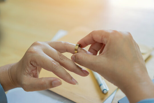 Finger, divorce and ring on hand of a woman at table with doubt, anxiety and depression