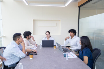Fototapeta premium Young indian business people or office employee sitting in meeting room discuss work with female boss. Corporate job. Teamwork.