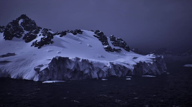 Nocturnal Antarctic glacier beneath storm sky, ink black sea dotted with faint ice, low contrast blue tones and brooding mood hinting at climate impact