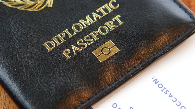 Diplomatic passport and plane ticket macro shot lying on wooden table with cinematic panning motion