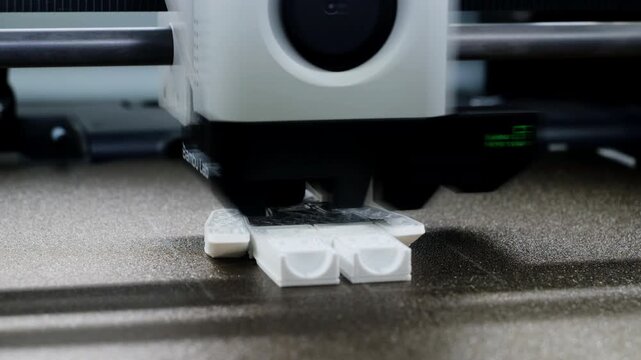 Close up view of a 3D printer printing a toy in fast timelapse showing the white print head moving quickly with dynamic motion blur during the process