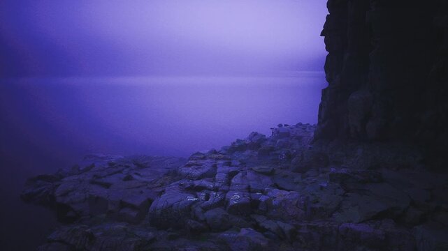 Ultraviolet twilight rocky shoreline wrapped in mist, soft long exposure water meeting jagged basalt, deep violet sky gradient, grainy texture, tranquil