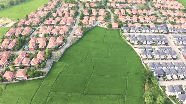 Land and community in Chiang Mai, San Sai district, Shot in March 2021, represent residential living surrounded by green rice field, vacant land. Urban sprawl extending from Chiang Mai city center.