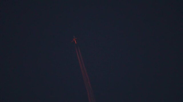 Orange contrails of the airplane in the sky during the sunset as seen from Rann of Kutch in Kutch, Gujarat, India. Contrails turn orange during the sunset in the sky as seen from the ground.