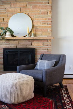 Living room with armchair, fireplace and patterned rug