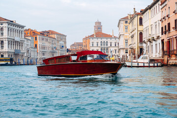 Boat travels through the waterways of Venice with historic buildings in the background © fotofabrika