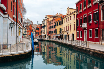 Canals in Venice show colorful buildings and calm waters during a cloudy day © fotofabrika