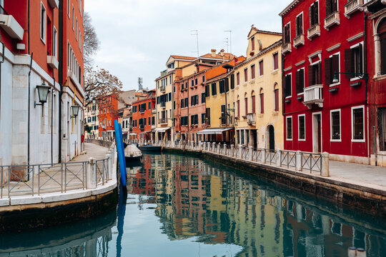 Canals in Venice show colorful buildings and calm waters during a cloudy day