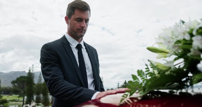 Man, casket and touch for respect at funeral with grief, goodbye and outdoor at cemetery for mourning. Person, coffin and reflection for death, greeting or farewell service at graveyard for burial