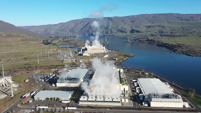 4K Aerial drone footage of a large data center campus with cooling steam, electrical substation along the Columbia River in The Dalles, Oregon, USA. Power demand for cloud computing AI infrastructure