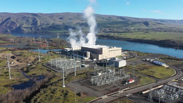 4K Aerial drone footage of a large data center campus with cooling steam, electrical substation along the Columbia River in The Dalles, Oregon, USA. Power demand for cloud computing AI infrastructure