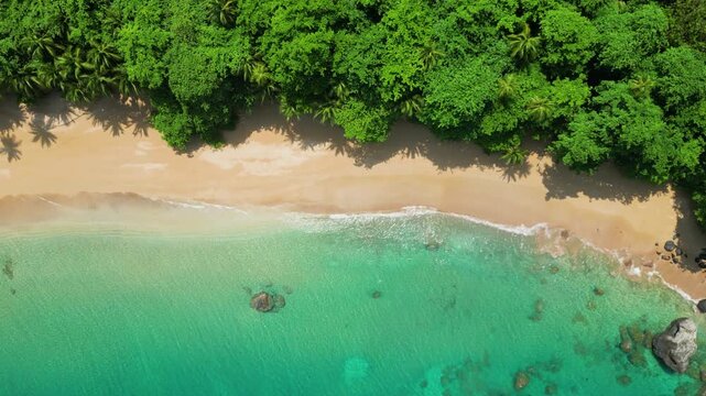 Top down drone shot of a boat floating at the Praia Macaco on sunny Prince island