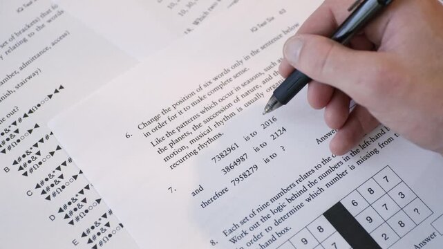 Student Hand Filling Out Multiple Choice Test Sheet, School Exam or Assessment Close-Up. IQ test