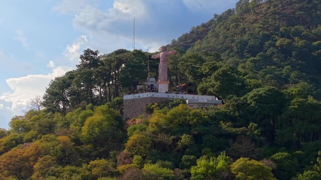 Telephoto aerial view of the Monumental Christ of Taxco on Atachi Hill surrounded by lush greenery, Taxco, Guerrero, Mexico