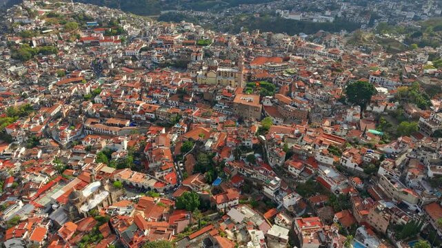 Panoramic aerial view dolly in the city of Taxco de Alarcon, Guerrero, Mexico with tiled roofs and soft evening light