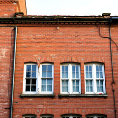 Naklejka premium Old brick building exterior featuring a row of windows