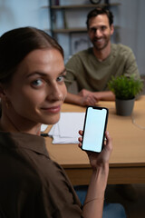 Homeowner couple reviewing solar savings app on smartphone at kitchen table