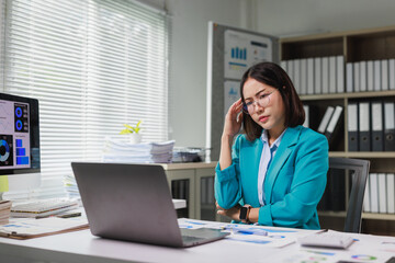 Obraz premium Stressed businesswoman suffering headache working in office