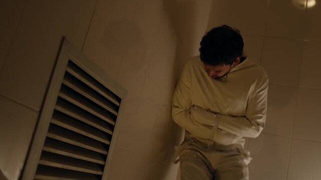 Man in straightjacket in cell, intense emotions and isolation