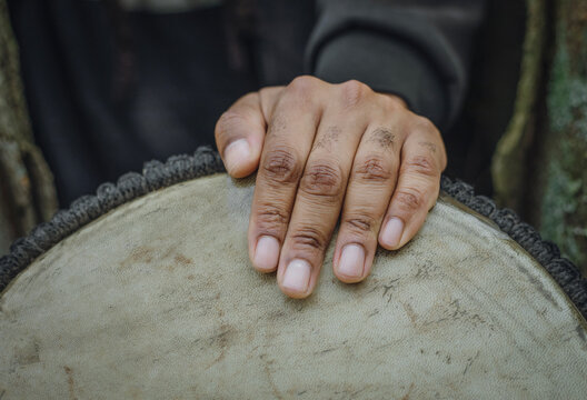 A hand rests on an African drum