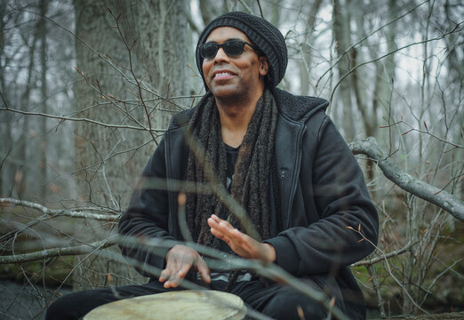Dreadlocked man performing on djembe