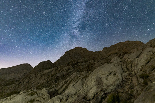 The Milky Way rising over a dark mountain silhouette