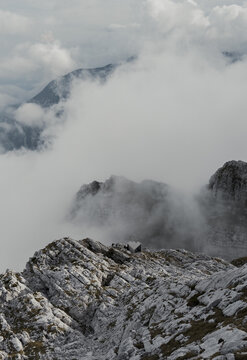 Jagged mountain peaks appearing through thick clouds
