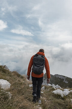 Man hiking up a steep, rocky trail in the mountains