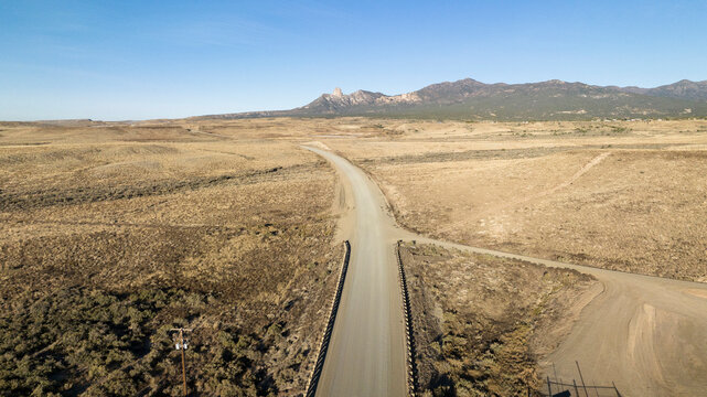 Aerial shot of a dirt road in a semi-arid, mountain landscape